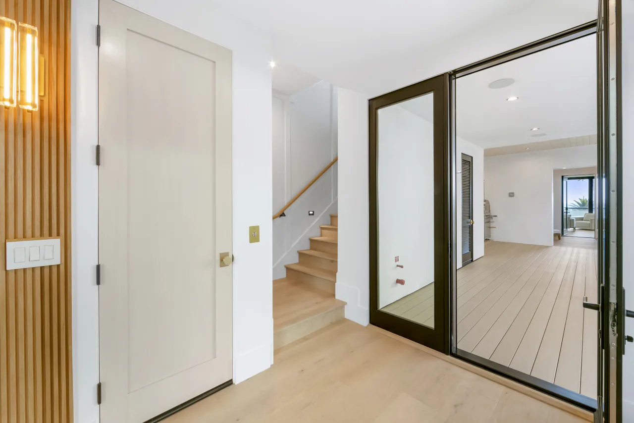 Entry hall with wood stairs and glass doors