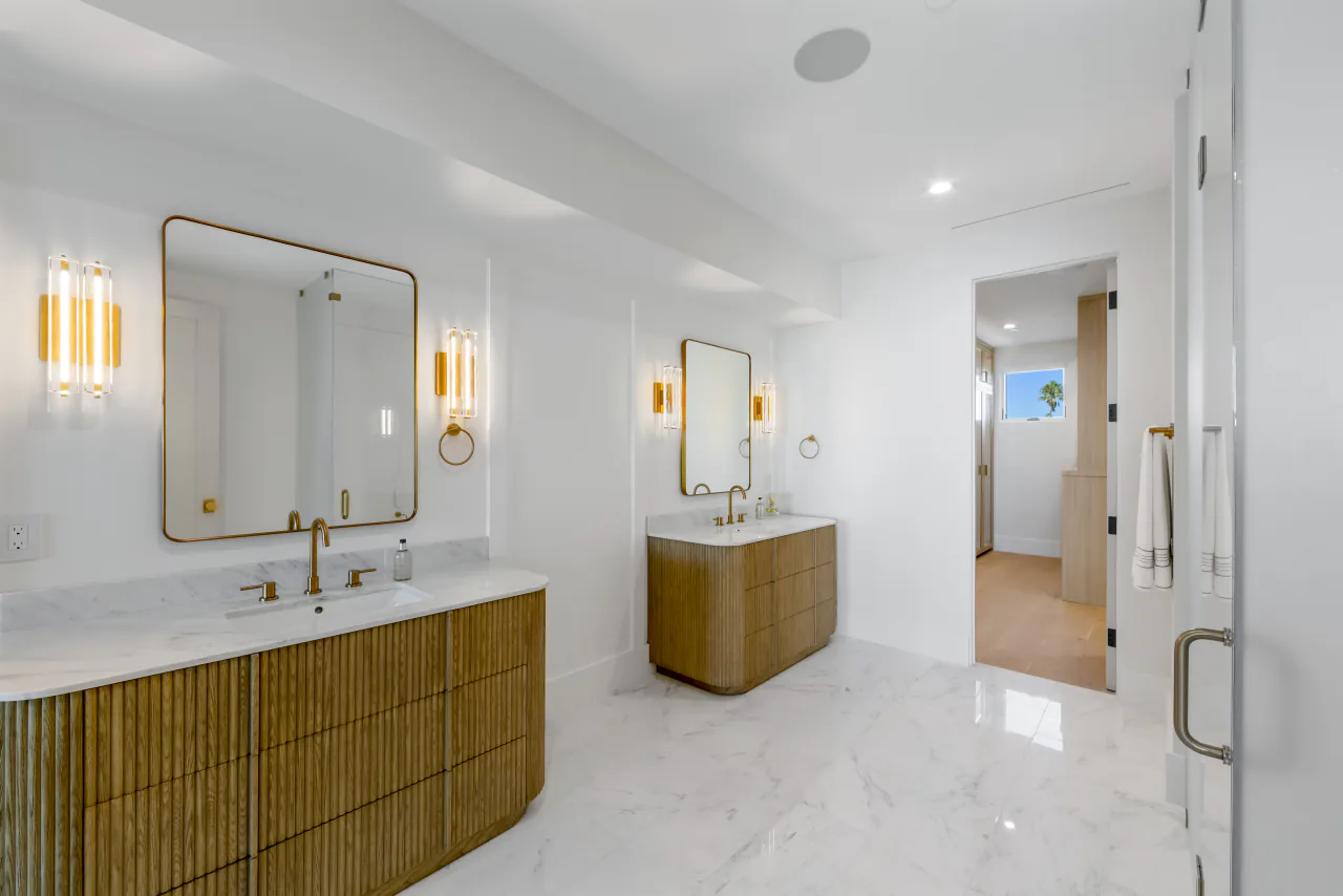 Bathroom with two wood vanities and wall mirrors
